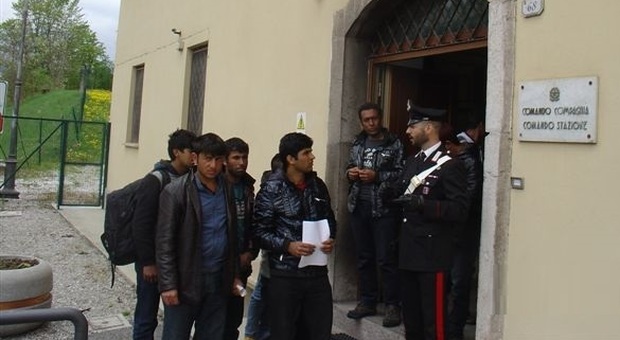 Un gruppo di profughi all'ingresso della caserma dei carabinieri di Tarvisio
