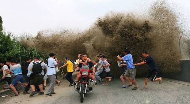 Cina, il fiume straripa all'improvviso: i passanti travolti dall'onda anomala