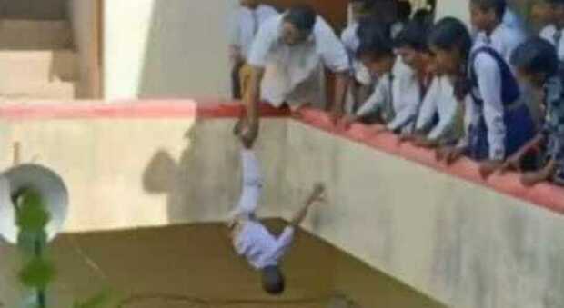 Punisce un alunno di cinque anni tenendolo per una gamba a testa in giù da un balcone