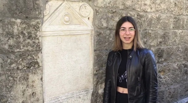 Una studentessa del Varrone spiega la lapide apposta sulla facciata dell'ex chiesa di San Pietro (foto dal video YouTube)