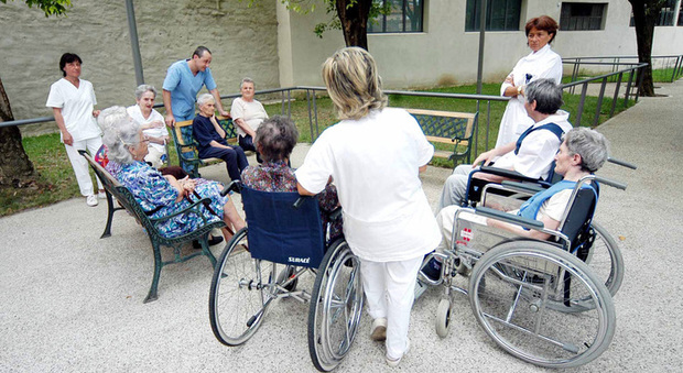 Anziani in una casa di riposo con operatrici e assistenti (Ansa)
