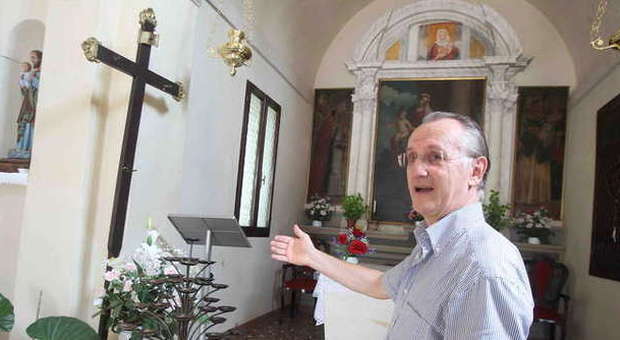 Don Ugo Gaspardo mostra il crocifisso