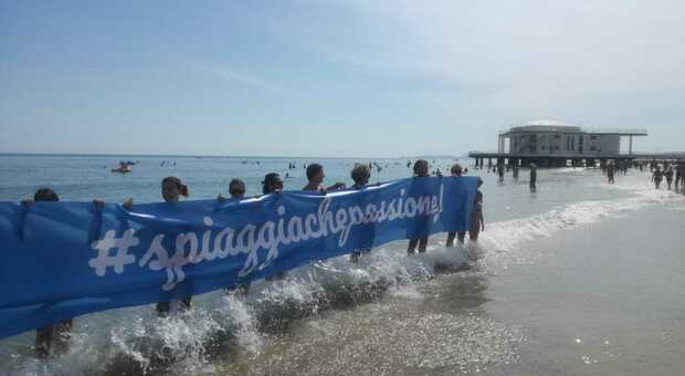 Catena umana in spiaggia a Senigallia, flashmob a sostegno delle imprese balneari: «Un lavoro, una passione»