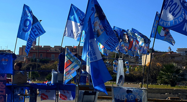 Bandiere che celebrano il terzo scudetto del Napoli in vendita su una bancarella: a dispetto della superstizione sono richiestissime