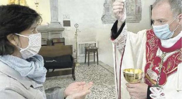 Il vescovo Giuseppe Pellegrini dà la comunione con mascherina e guanti