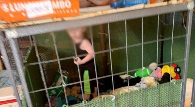 Bambino di un anno e mezzo tenuto chiuso in gabbia: intorno a lui animali, armi e marijuana