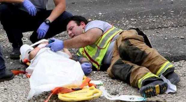 Il pompiere che tranquillizza la bimba in attesa dei soccorsi (Web)