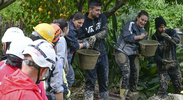 Soccorritori e cittadini spalano il fango a Ischia