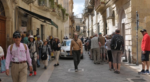 I turisti a spasso per Lecce in mezzo alle auto