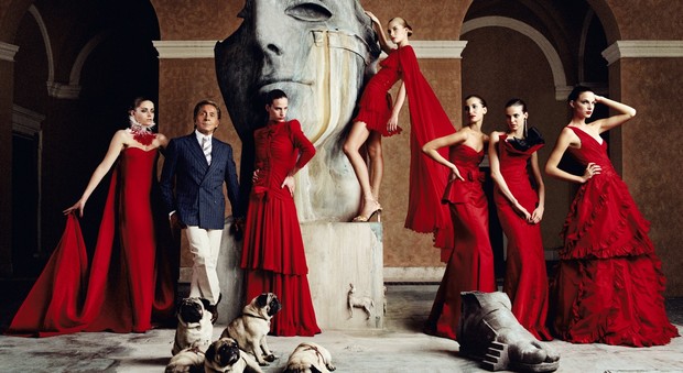 Nella foto il couturier Valentino Garavani con i suoi carlini e alcune mannequin che indossano le sue creazioni