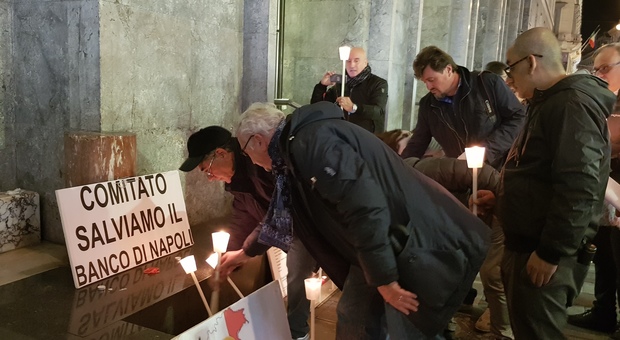 Manifestanti depongono ceri sotto la sede centrale dell'ex Banco di Napoli