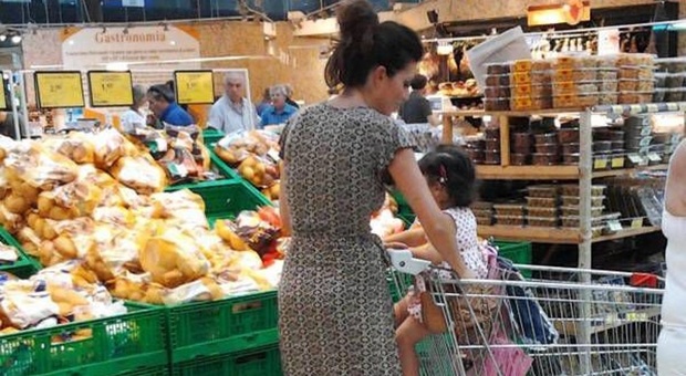 Una donna al supermercato con la figlia