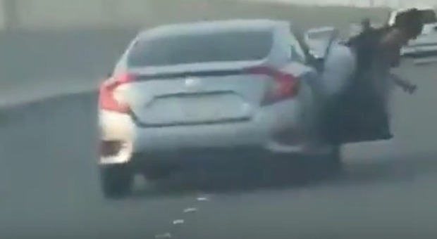 Cerca di colpire un automobilista dal finestrino, ma la portiera della sua auto si apre in corsa