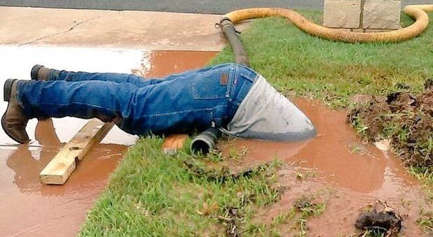 L'idraulico fa un tuffo nel fango per il suo lavoro: la foto è virale