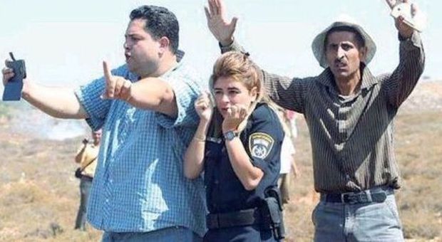 Due palestinesi proteggono la poliziotta (foto Shaul Golan)