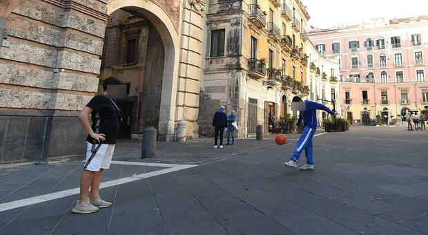 Ragazzini giocano a pallone in piazza Flavio Gioia