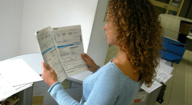 Una donna controlla delle cartelle esattoriali con le somme da versare al fisco per ripagare i debiti.
