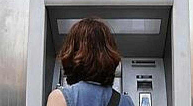 Una donna davanti a un postamat