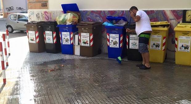 Un cittadino ripulisce il piazzale dalla spazzatura