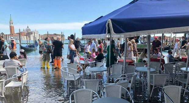 Acqua alta in agosto (ma senza passerelle), turisti con gli stivali e bambini a giocare a piedi nudi come in spiaggia: arrivano i vigili