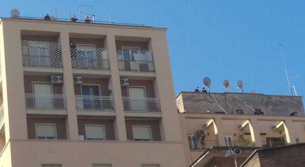 Domenica delle palme: il prete dice messa sul sagrato, fedeli affacciati da balconi e tetti