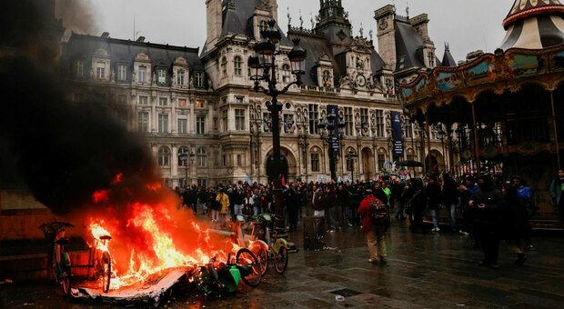 Scontri a Parigi dopo l'ok alla riforma delle pensioni: vetrine spaccate e bici in fiamme. Terrore in pieno centro