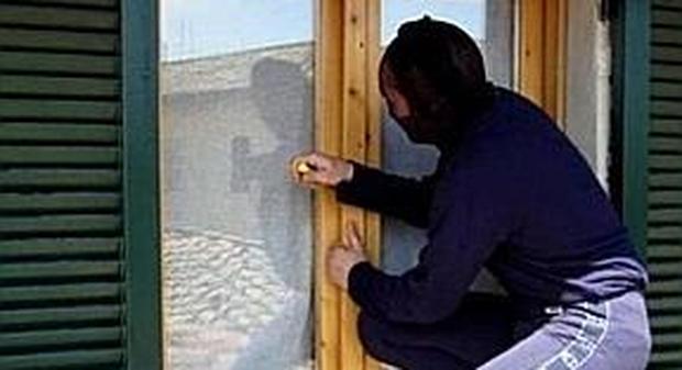 Un ladro mentre forza una finestra