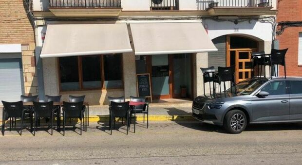 Parcheggio selvaggio nello spazio del bar, sull'auto spuntano tavolini e sedie. La foto è virale: «Sopra c'è più fresco»