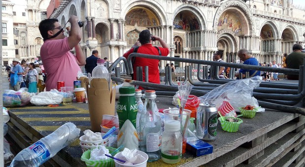 Le immondizie abbandonate dai turisti sulle passerelle dell’acqua alta in piazza San Marco
