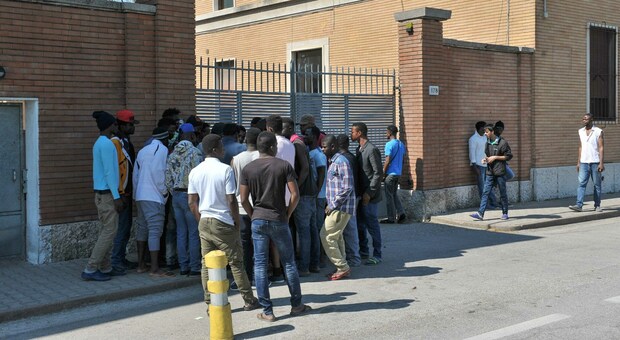 Un gruppo di richiedenti asilo davanti al centro d'accoglienza nell'ex caserma Serena