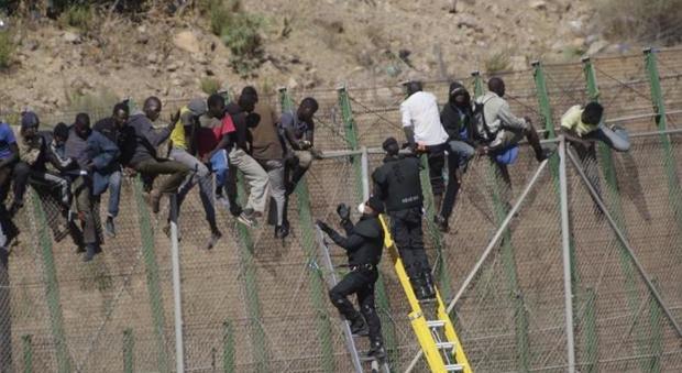 Migranti mentre tentano di scavalcare la frontiera di Melilla