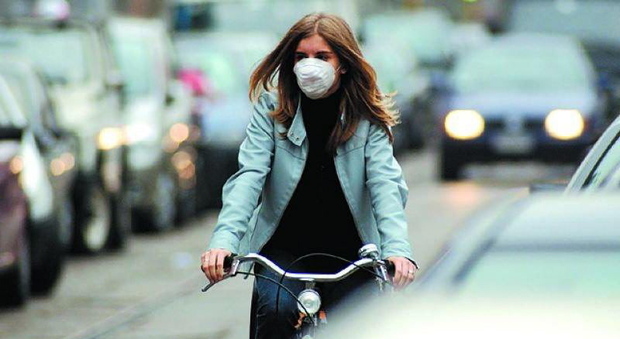 Foto d'archivio di una ciclista con la mascherina per proteggersi dallo smog