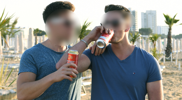 Due ragazzi bevono la birra in spiaggia