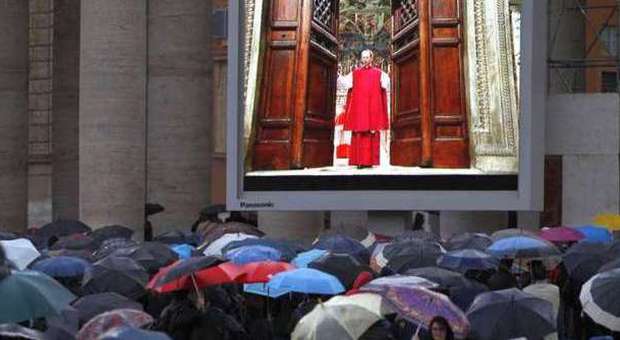 People watch on a video monitor in St. Peter's Square