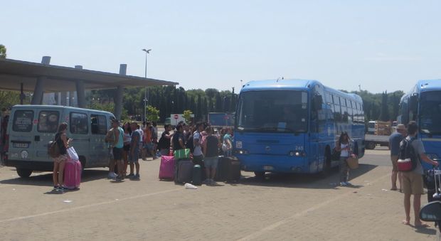 Turisti in coda per salire su un bus
