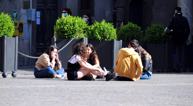 Giovani seduti in piazza del Comune