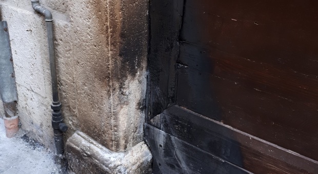 Ascoli, teppisti incendiano portone in piena notte nel centro storico