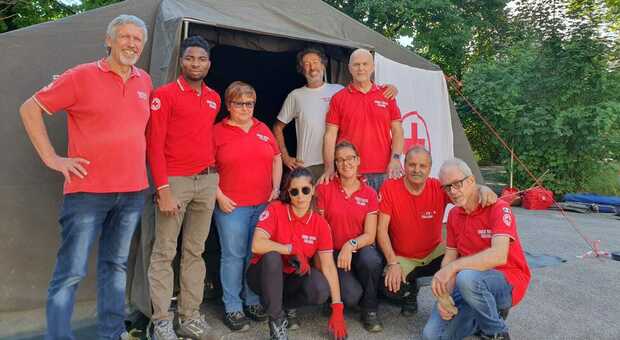 Un gruppo di volontari della Croce Rossa davanti a una tenda che ospitava migranti a Cavarzano di Belluno