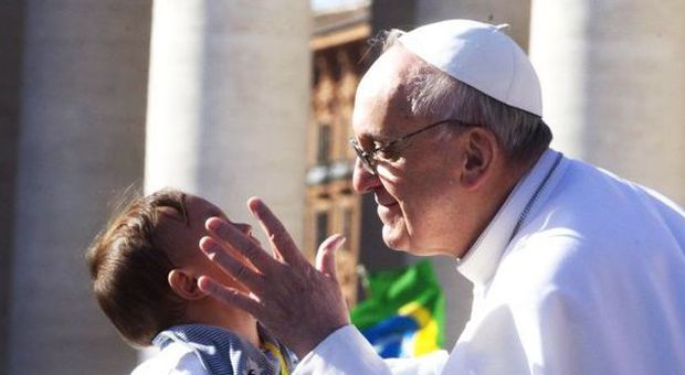 Papa Francesco bacia un bambino tra la folla