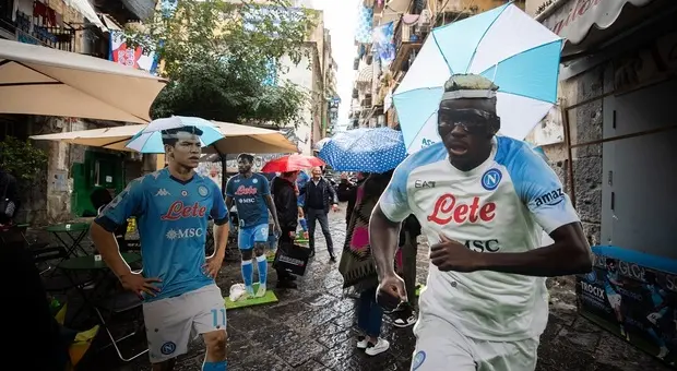Le sagome dei calciatori con gli ombrellini anti-pioggia