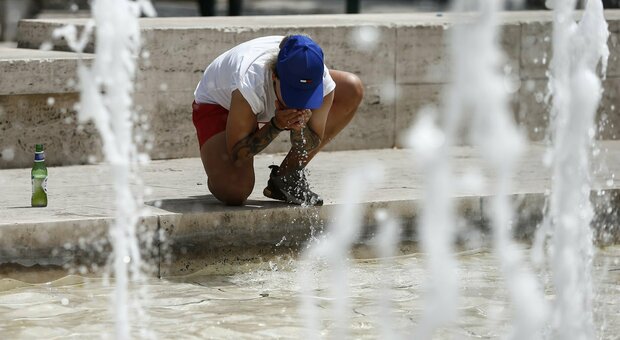 Un turista si rinfresca in una fontana a Roma