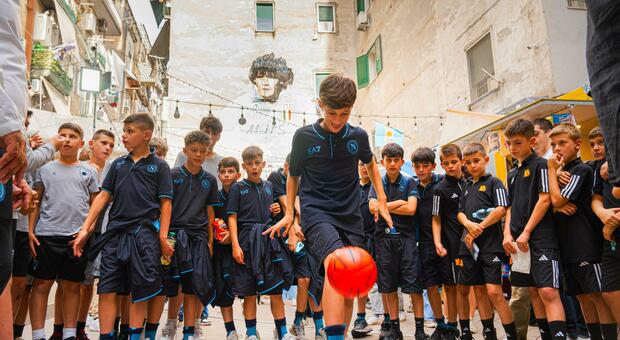 Il palleggio di un piccolo calciatore del Napoli davanti al murale di Maradona ai Quartieri spagnoli