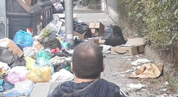 Roma, la strada è bloccata dai rifiuti: disabile in carrozzina non riesce a passare
