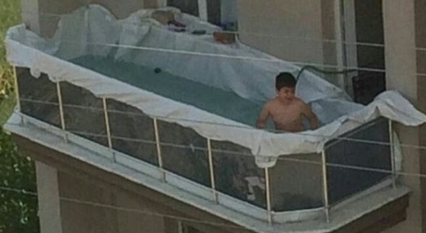 Piscina sul balcone, il bambino si diverte e la foto è virale...ma c'è anche chi ironizza