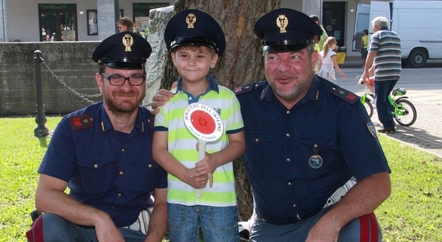 Un bambino e due agenti in una delle iniziative svolte per la sicurezza stradale