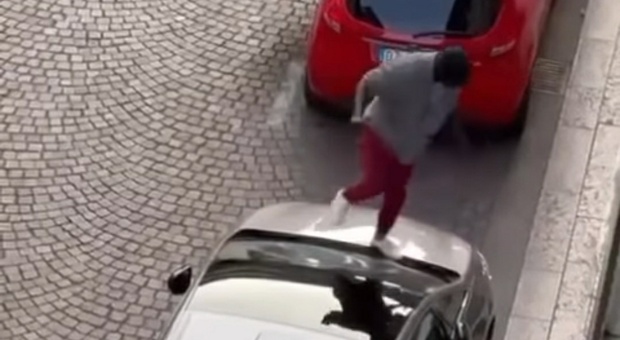 Straniero sfonda i parabrezza delle auto posteggiate in strada: terrore in centro storico VIDEO