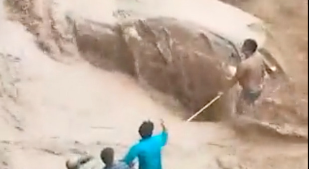 Donna dentro un'auto risucchiata dal fiume: un gruppo di uomini la salva facendo la catena umana
