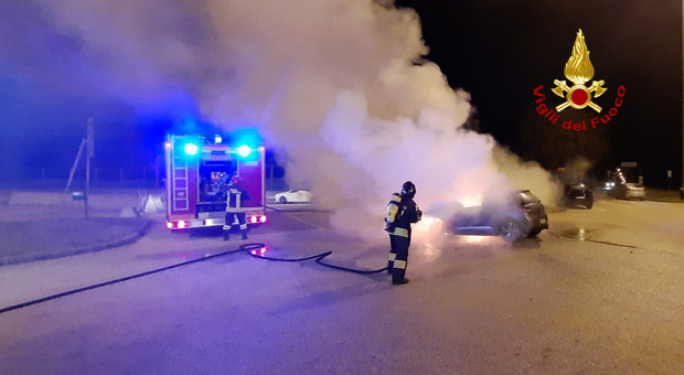 I vigili del fuoco mentre spengono l'auto in fiamme