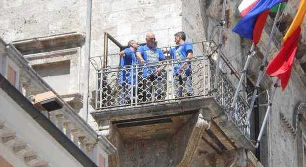 I tre operai sul balconcino di palazzo dei Capitani