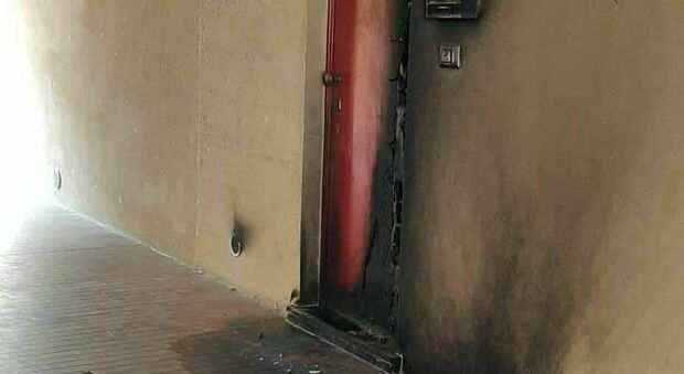 La porta dell'appartamento colpita dal piromane